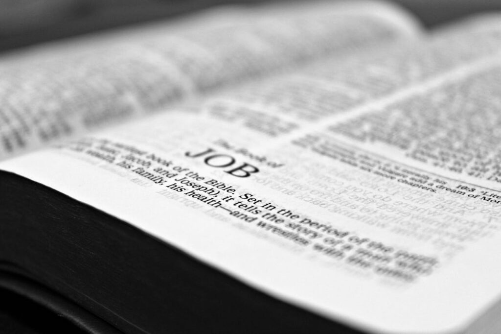 Close-up black and white image focusing on a Bible page with the Book of Job.